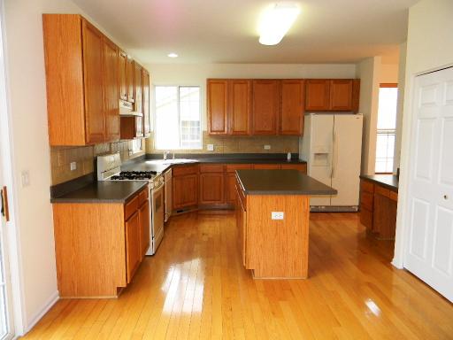 1782 Prairie Ridge Circle Lindenhurst, IL 60046 - Photo 6 of 15 a kitchen with stainless steel appliances a sink a stove a refrigerator cabinets and a dining table