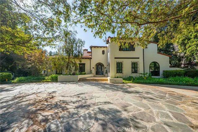 a view of a white house with a yard and large tree