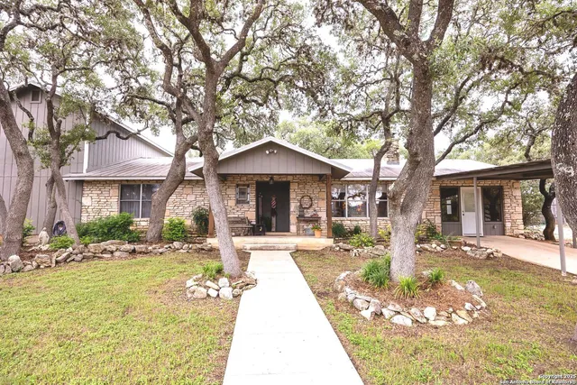 a front view of a house with a yard and potted plants