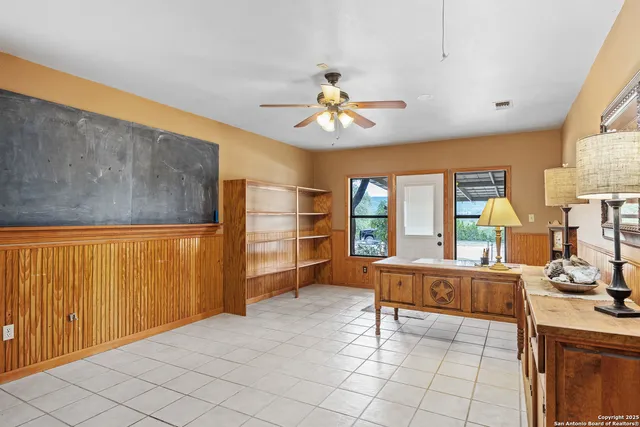 a living room with furniture a flat screen tv and a large window