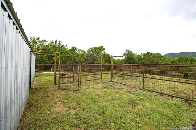 a view of a yard with wooden fence