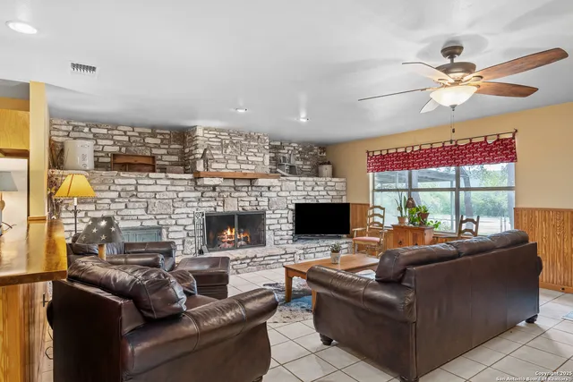 a living room with fireplace furniture and a floor to ceiling window