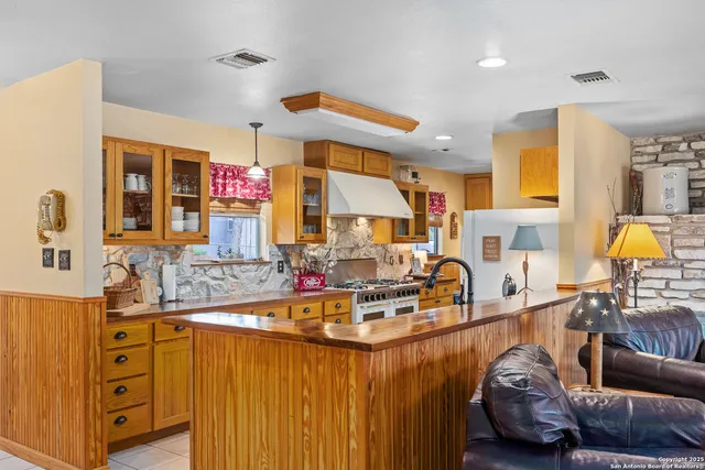 a kitchen with stainless steel appliances granite countertop a sink and a refrigerator