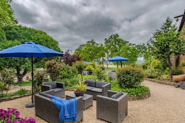 an aerial view of a house with a yard and outdoor seating