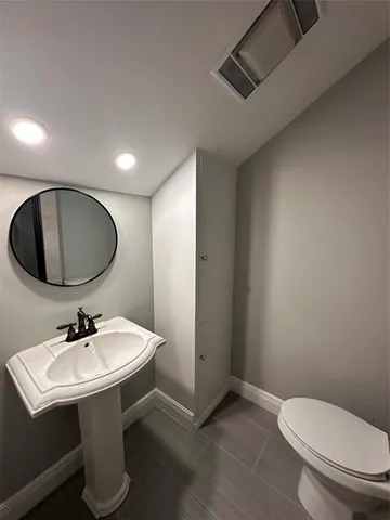 a white toilet sitting next to a bathroom sink