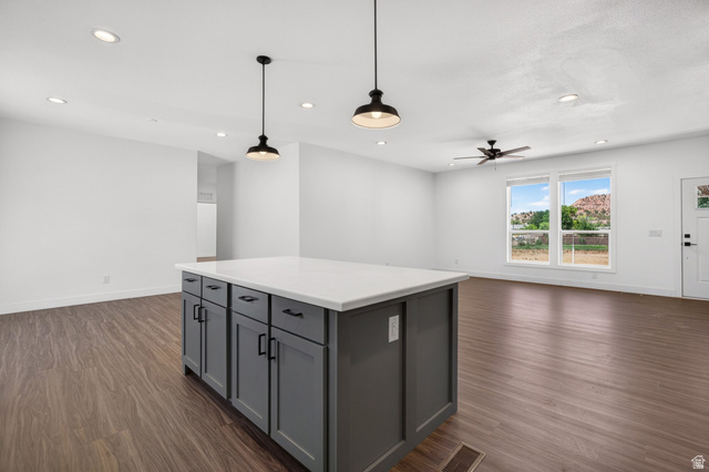 464 Jessop Avenue Hildale, UT 84784 - Photo 10 of 73 Kitchen island with a light-toned countertop and dark cabinetry, illuminated by two pendant lights and recessed ceiling lights