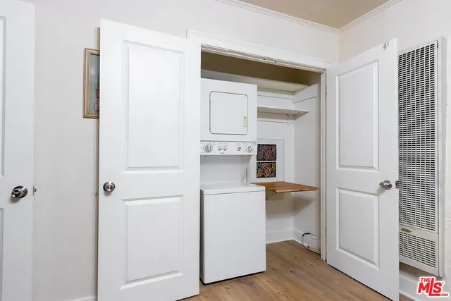a view of a hallway with wooden floor and closet