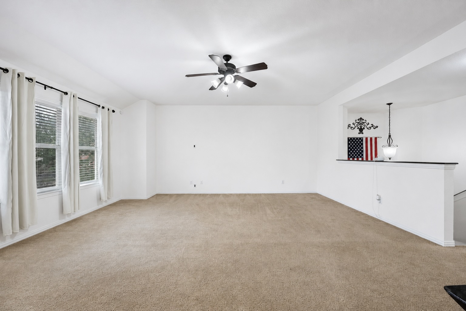 2415 Elkhorn Ranch Road Leander, TX 78641 - Photo 15 of 38 A spacious living area with warm carpeting and a ceiling fan, illuminated by ample natural light from multiple windows.