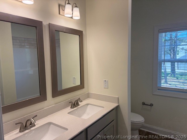 180 Rabbit Run Drive Smithfield, NC 27577 - Photo 7 of 19 a bathroom with a sink vanity granite toilet and a mirror