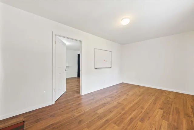 a view of a patio with a table and chairs under an umbrella with a barbeque