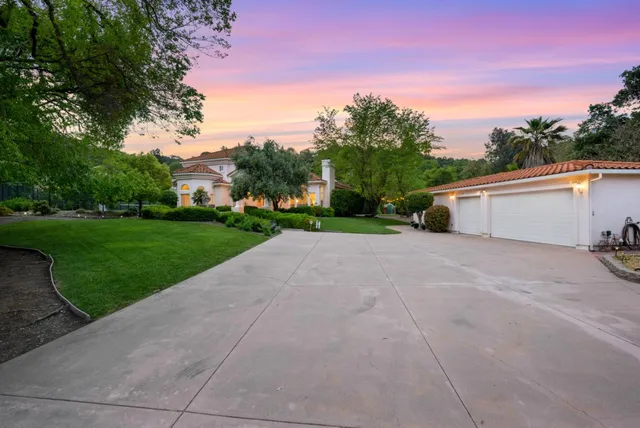 a view of a house with backyard and trees