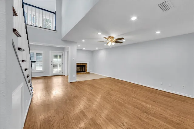a view of empty room with wooden floor and fireplace