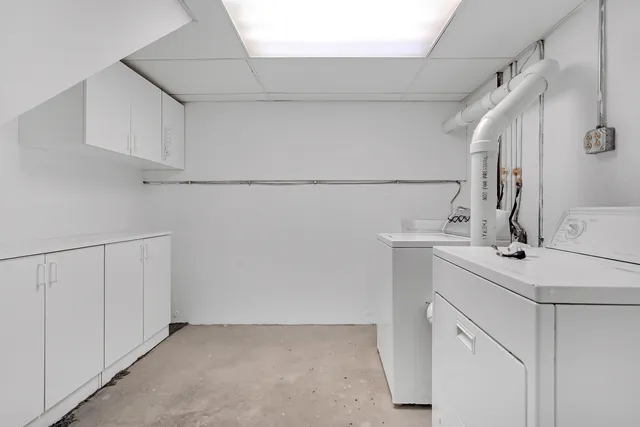 a utility room with cabinets washer and dryer
