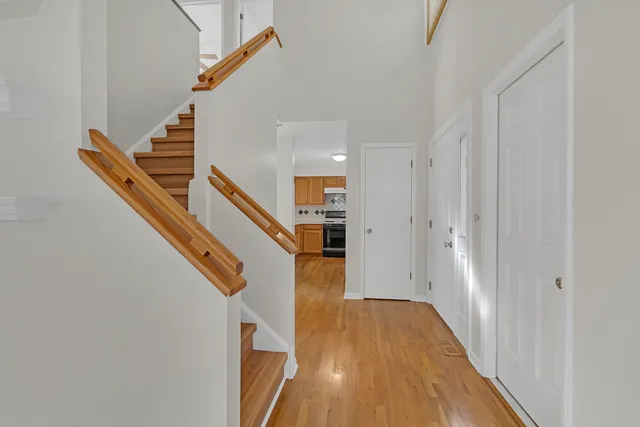 a view of a hallway with wooden floor and staircase