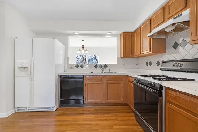 a kitchen with stainless steel appliances granite countertop a stove a sink and a refrigerator