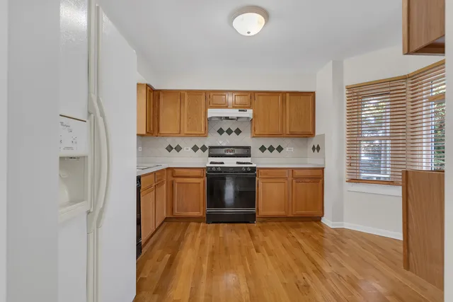 a kitchen with granite countertop a stove and a refrigerator