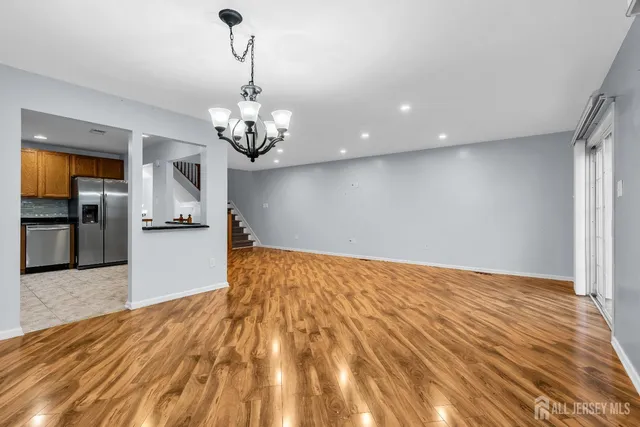 a kitchen with stainless steel appliances kitchen island granite countertop a table chairs stove and refrigerator