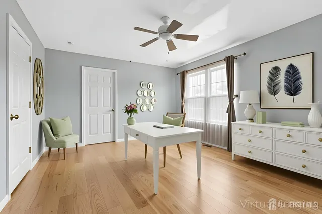 an empty room with a chandelier fan and windows