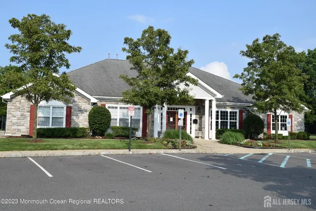 a view of a livingroom with a fireplace a chandelier and wooden floor