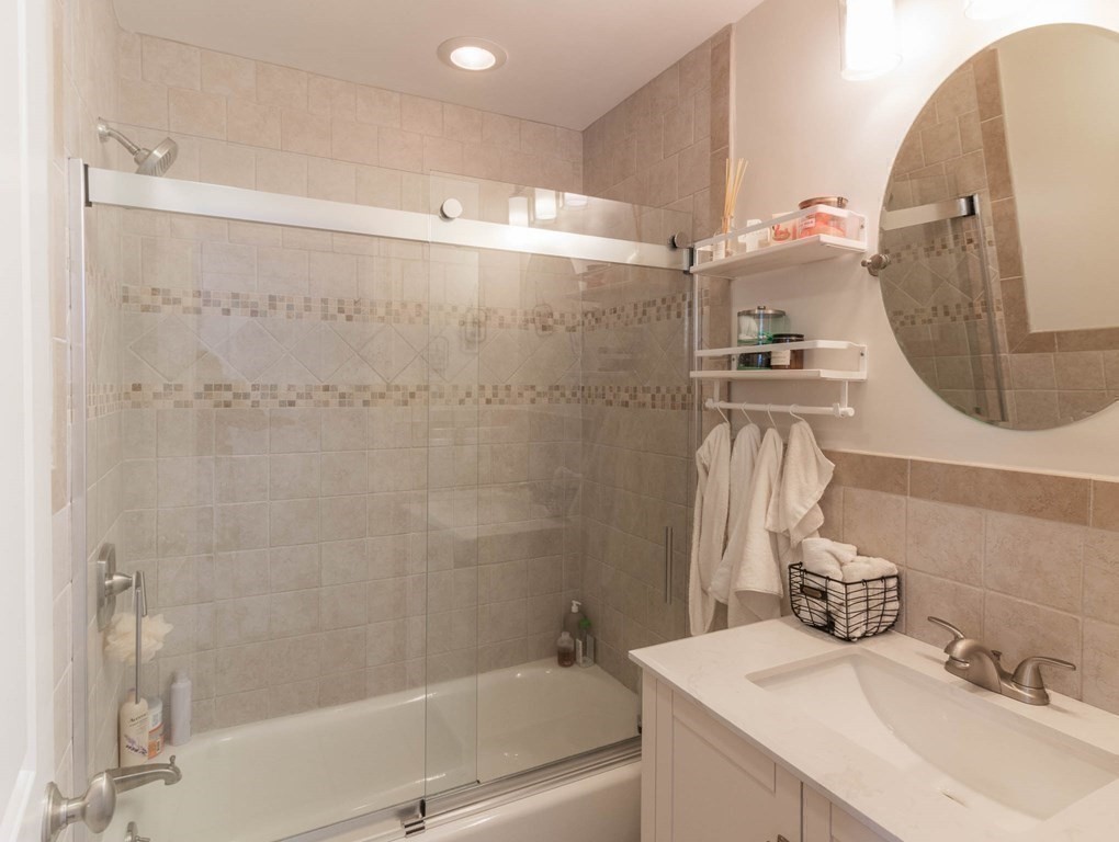 73 K Street Hull, MA 02045 - Photo 30 of 42 a bathroom with a sink and mirror with bathtub