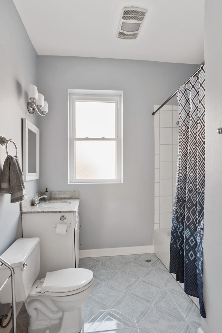 5556 North Wayne Avenue Chicago, IL 60640 - Photo 16 of 37 a bathroom with a toilet sink and mirror