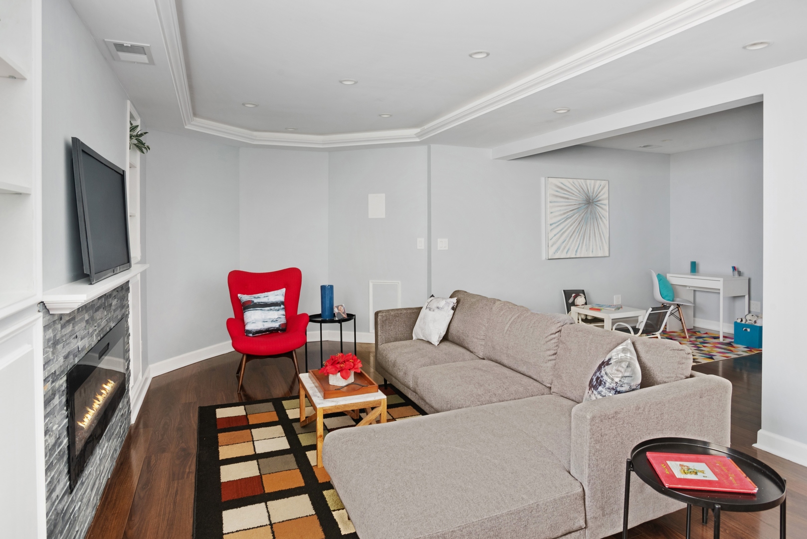 5556 North Wayne Avenue Chicago, IL 60640 - Photo 22 of 37 a living room with furniture a flat screen tv and a fireplace