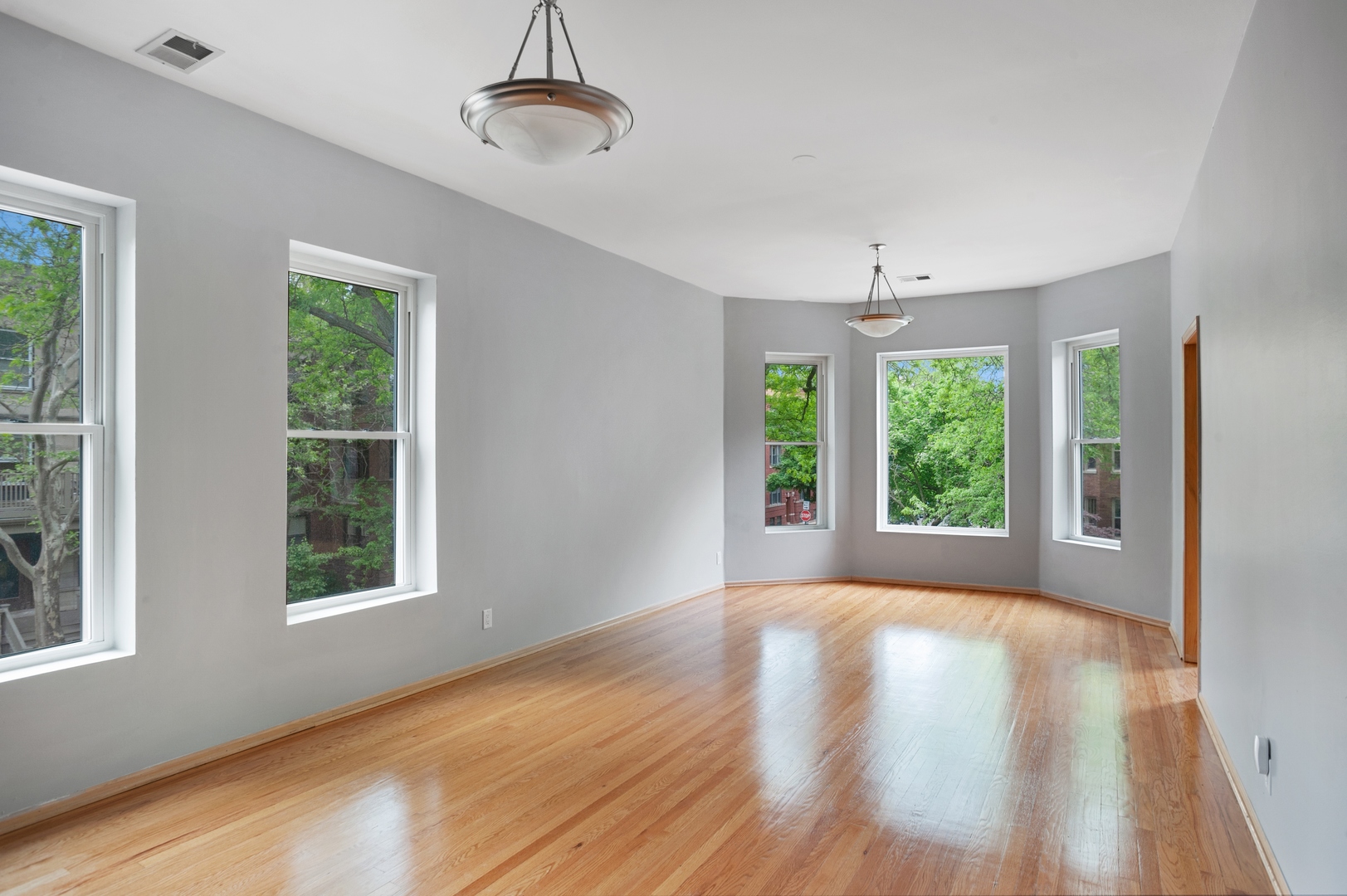 5556 North Wayne Avenue Chicago, IL 60640 - Photo 29 of 37 a view of an empty room with wooden floor and a window