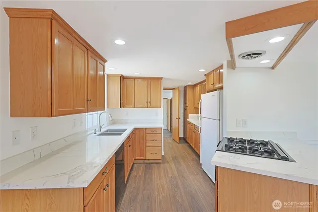 a kitchen with stainless steel appliances granite countertop a sink stove and refrigerator