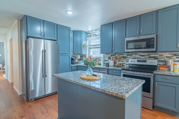 1689 Pleasant Ridge Road Huntland, TN 37345 - Photo 13 of 44 a kitchen with granite countertop stainless steel appliances a refrigerator a stove a sink cabinets and wooden floor