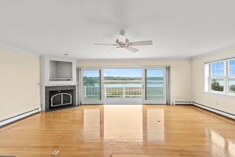 a view of an empty room with a fireplace and a window