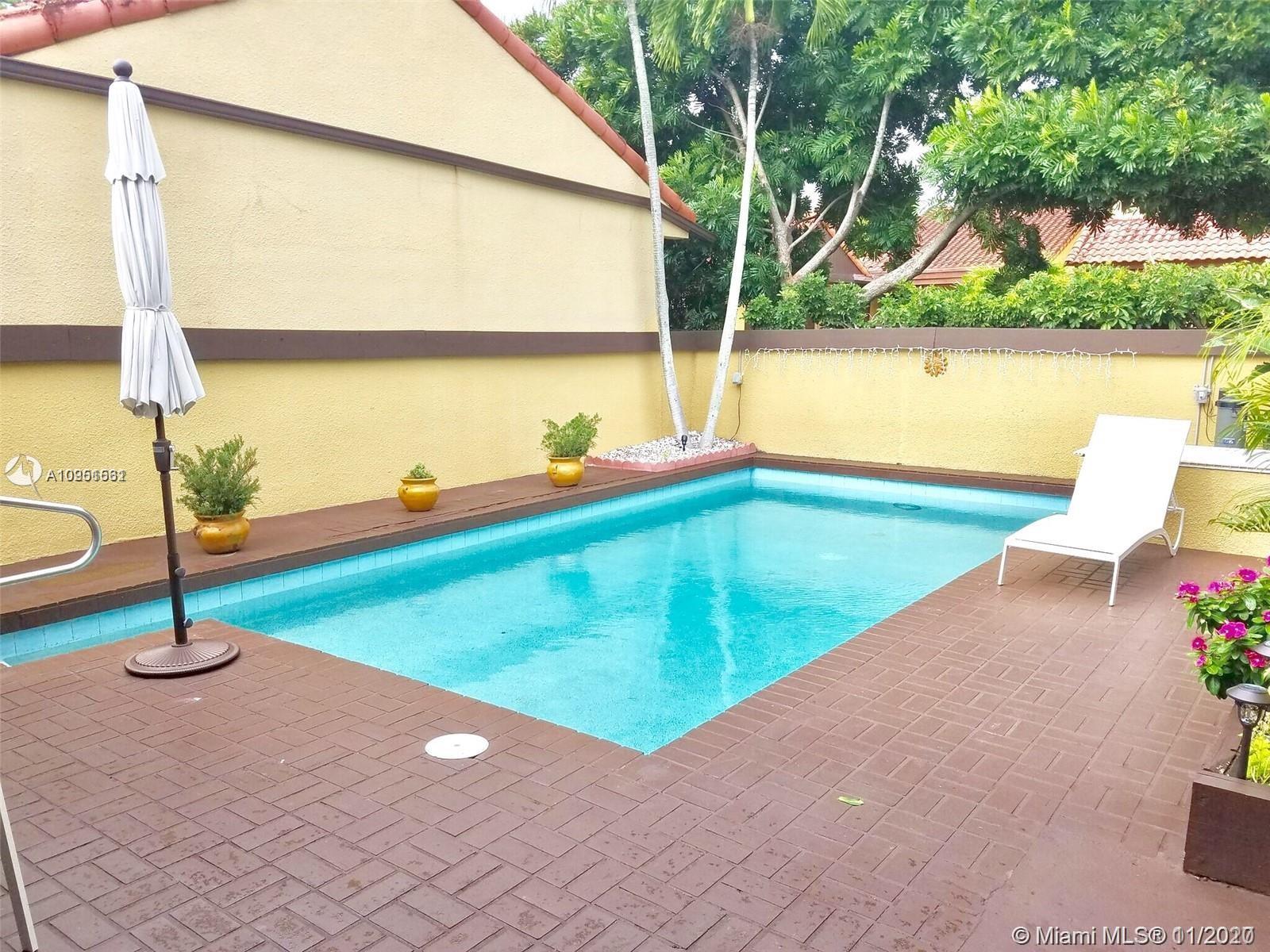 a view of a swimming pool with a yard and chair