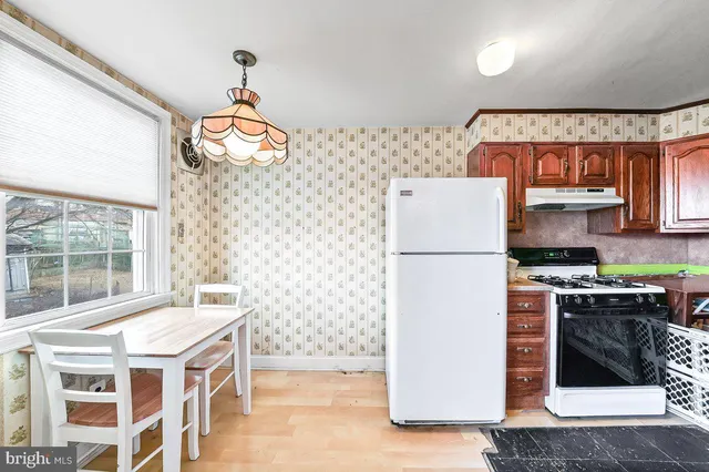 a kitchen with stainless steel appliances granite countertop a refrigerator a stove a sink and a microwave