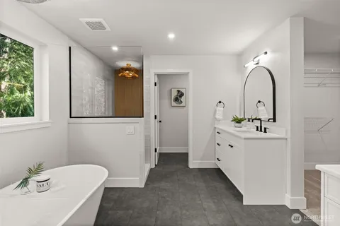 a bathroom with a double vanity sink mirror and bathtub