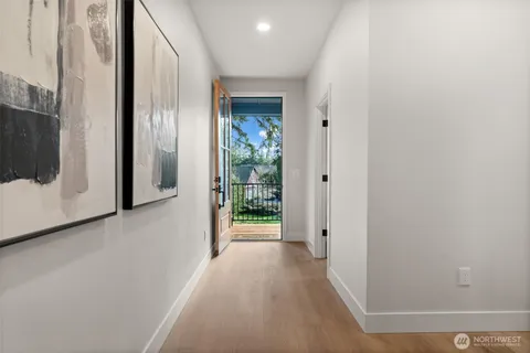 a view of a hallway with wooden floor and a cabinet