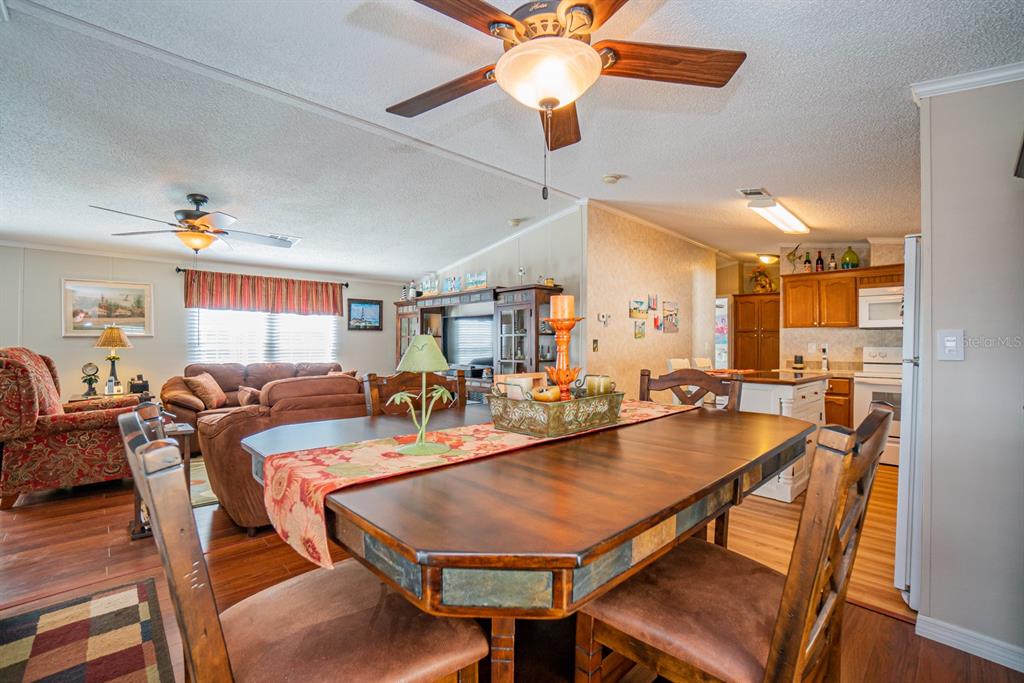 10303 Burnt Store Road, Unit 203 Punta Gorda, FL 33950 - Photo 12 of 41 a dining room with furniture a chandelier and wooden floor