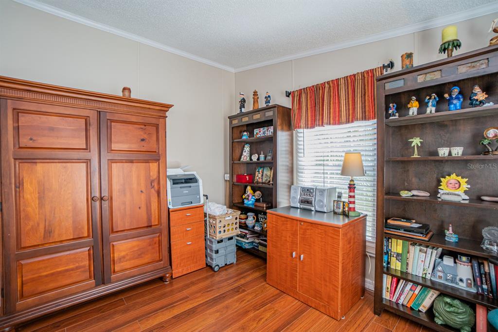 10303 Burnt Store Road, Unit 203 Punta Gorda, FL 33950 - Photo 18 of 41 a room with wooden furniture and a book shelf