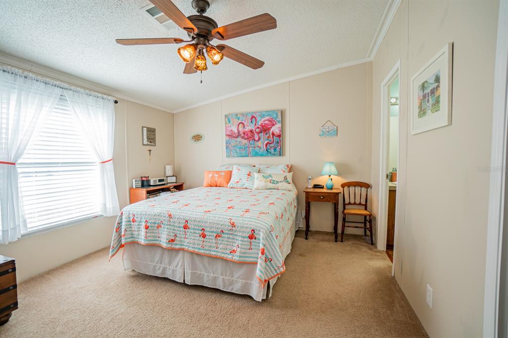 10303 Burnt Store Road, Unit 203 Punta Gorda, FL 33950 - Photo 19 of 41 a bedroom with a bed and a chandelier