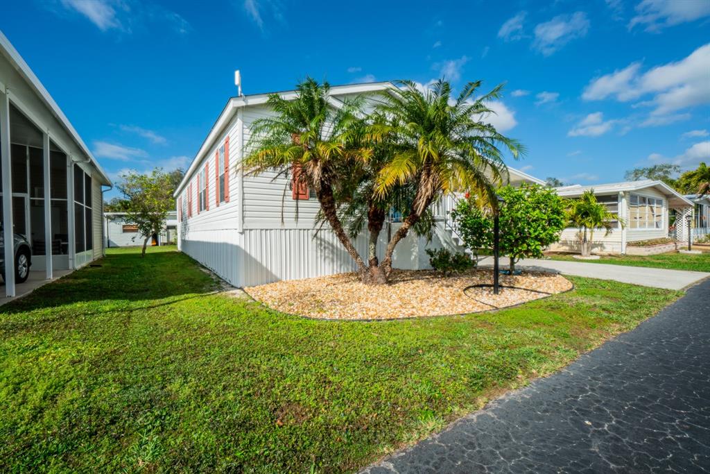 10303 Burnt Store Road, Unit 203 Punta Gorda, FL 33950 - Photo 30 of 41 a palm tree sitting in front of a house with a big yard