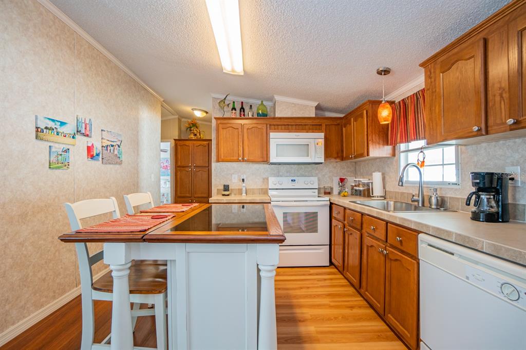 10303 Burnt Store Road, Unit 203 Punta Gorda, FL 33950 - Photo 6 of 41 a kitchen with stainless steel appliances kitchen island granite countertop a sink and cabinets