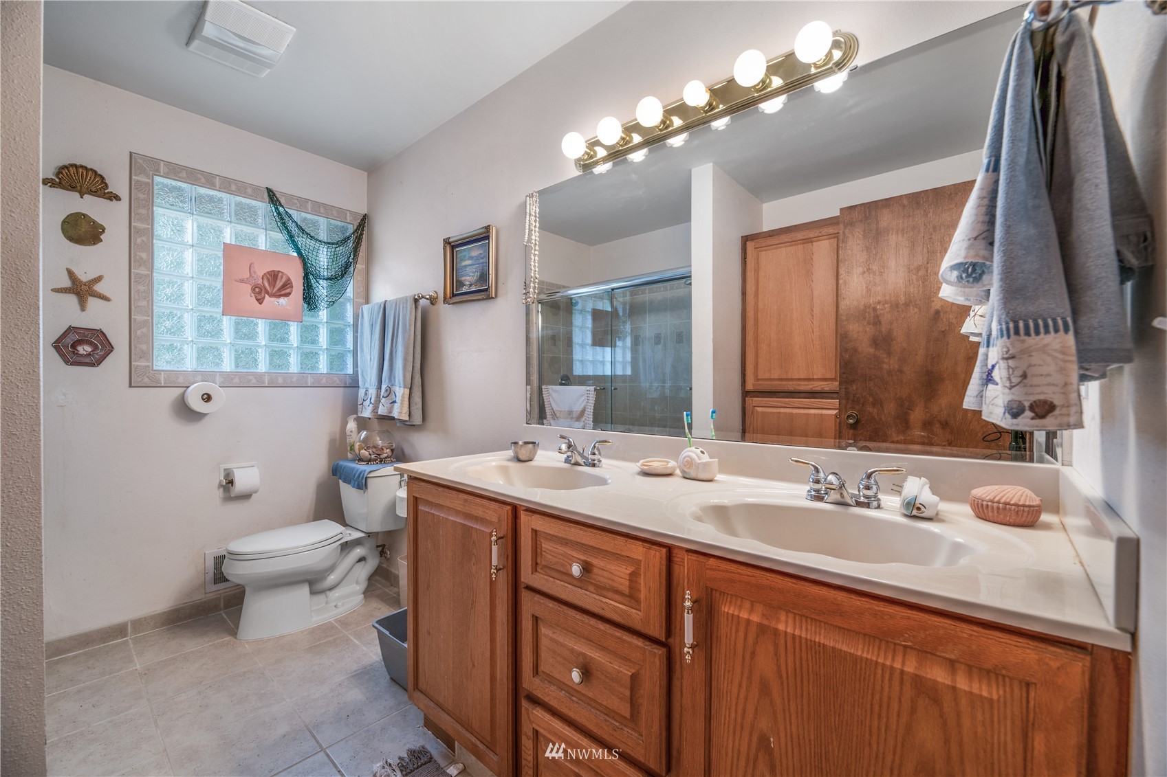 17315 Clover Road Bothell, WA 98012 - Photo 20 of 24 a bathroom with a toilet a sink a large mirror and a shower
