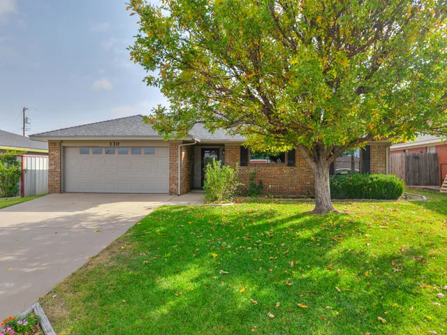 a front view of a house with a yard and a garage