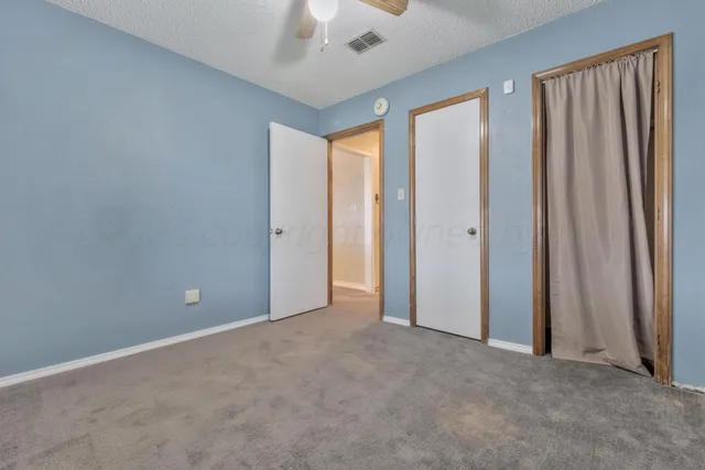 an empty room with window and closet area
