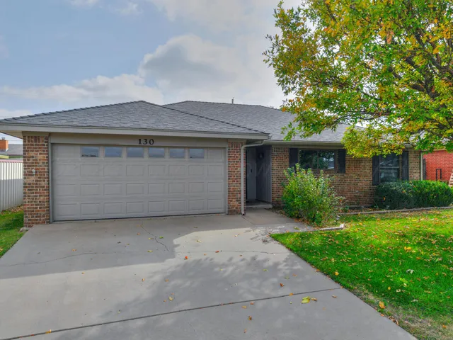 a front view of a house with a garden and garage