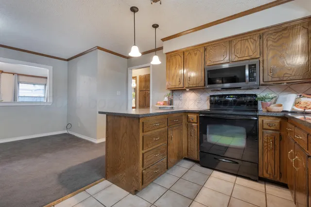 a kitchen with stainless steel appliances granite countertop a refrigerator a stove a sink and a microwave