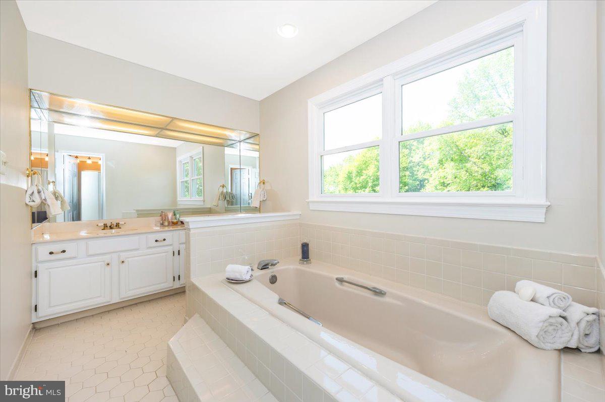 8412 Dasher Court Gaithersburg, MD 20882 - Photo 32 of 83 a large white tub sitting in a bathroom next to a window
