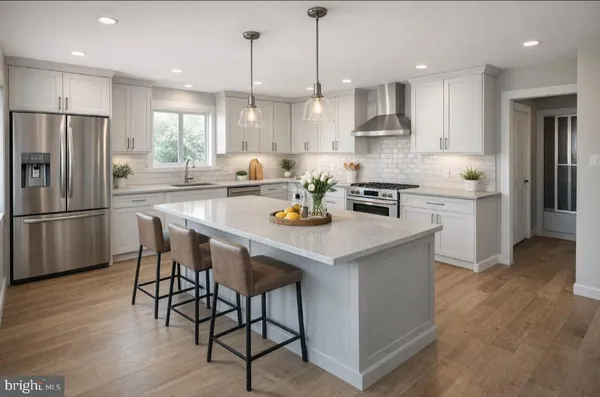 a kitchen with stainless steel appliances granite countertop a table chairs refrigerator and sink