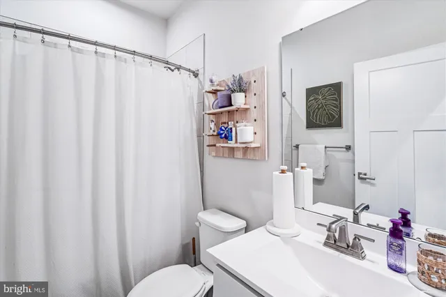 a bathroom with a sink a toilet and shower curtain