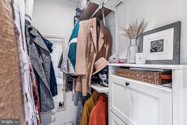 a view of walk in closet with clothes and shoes