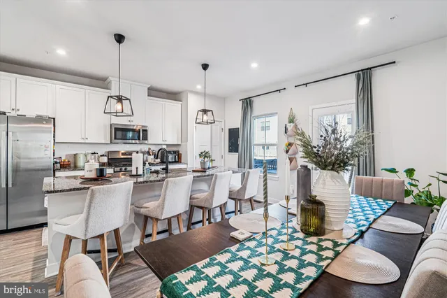 a living room with furniture kitchen view and a chandelier