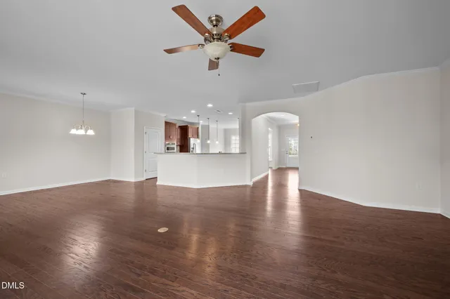 a view of a livingroom with wooden floor and a ceiling fan